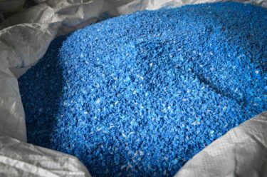 Blaue Kunststoff Flakes nach der Zerkleinerung in einem Big Bag