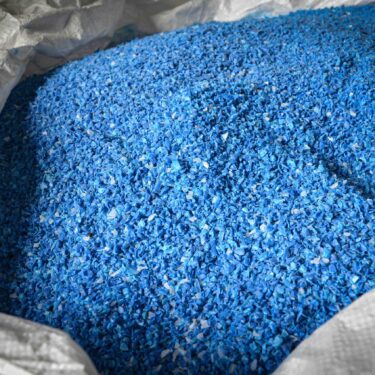 Blaue Kunststoff Flakes nach der Zerkleinerung in einem Big Bag