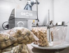 GROSS Brikettpresse mit Absackkarussel und gefüllten Tüten mit runden Holzbriketts
